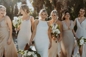 Bride with her bridesmaids walking and laughing at ACRE Los Cabos