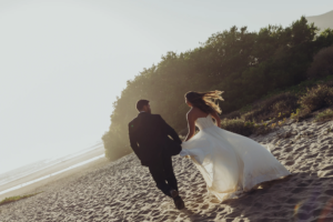 Bride and groom running off to the sunset