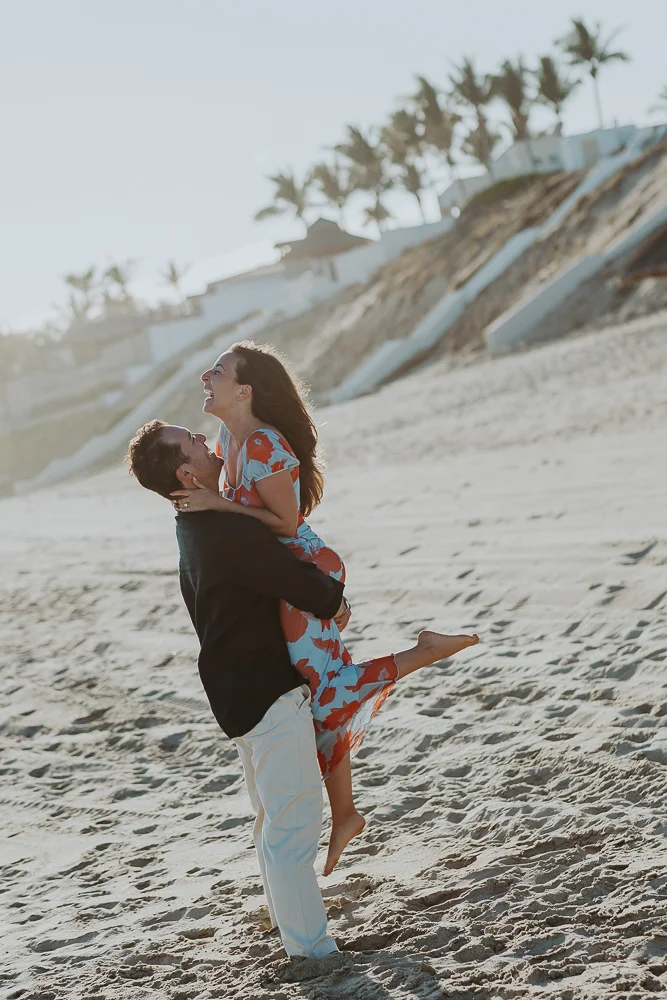 happy couple, he picks her up at beach