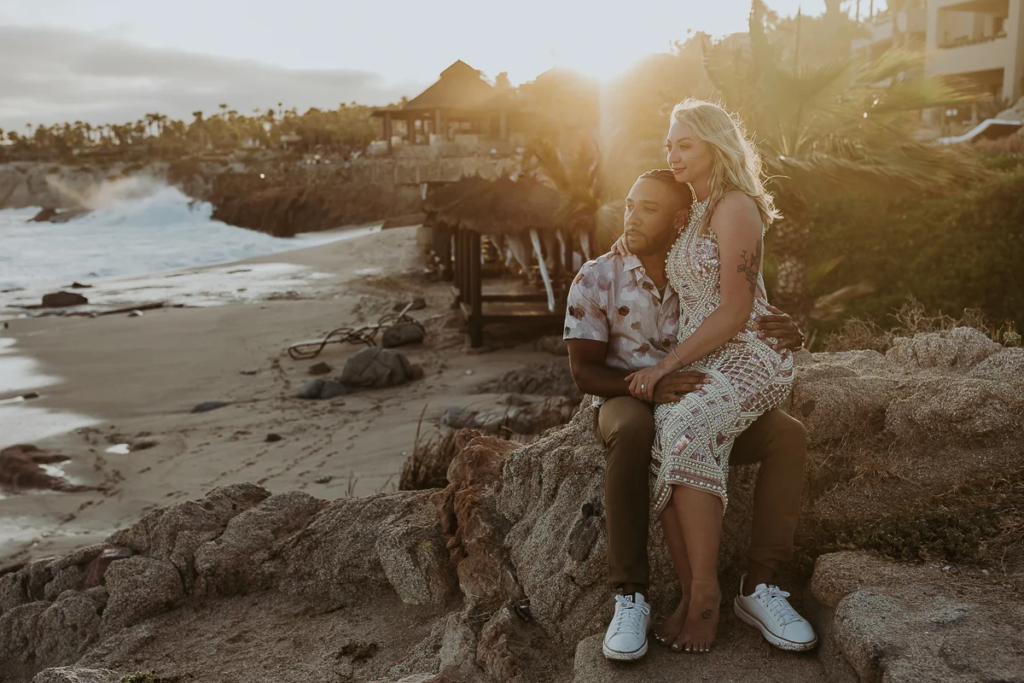 Couple pose for photo with sunset and Esperanza Resort in the background