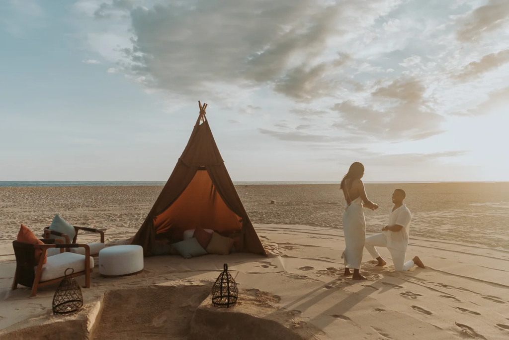 Proposal set up with tippy, man gets on one knee with sunset at the beach