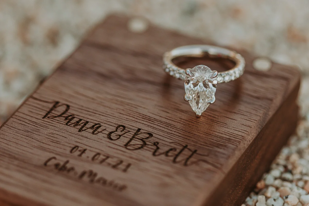 detail shot of an engagement ring on an engraved box