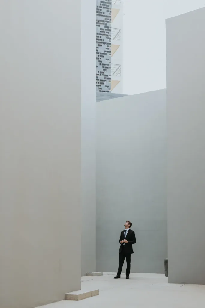Groom admires The Cape Hotels architecture with big concrete walls