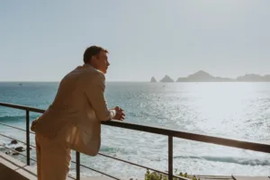 Groom admires landscape from the hotel in Los Cabos