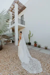 Bride with wedding gown and veil looks away from the camera
