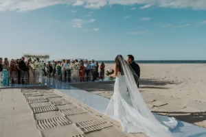 Bride walking down the aisle at beach ceremony