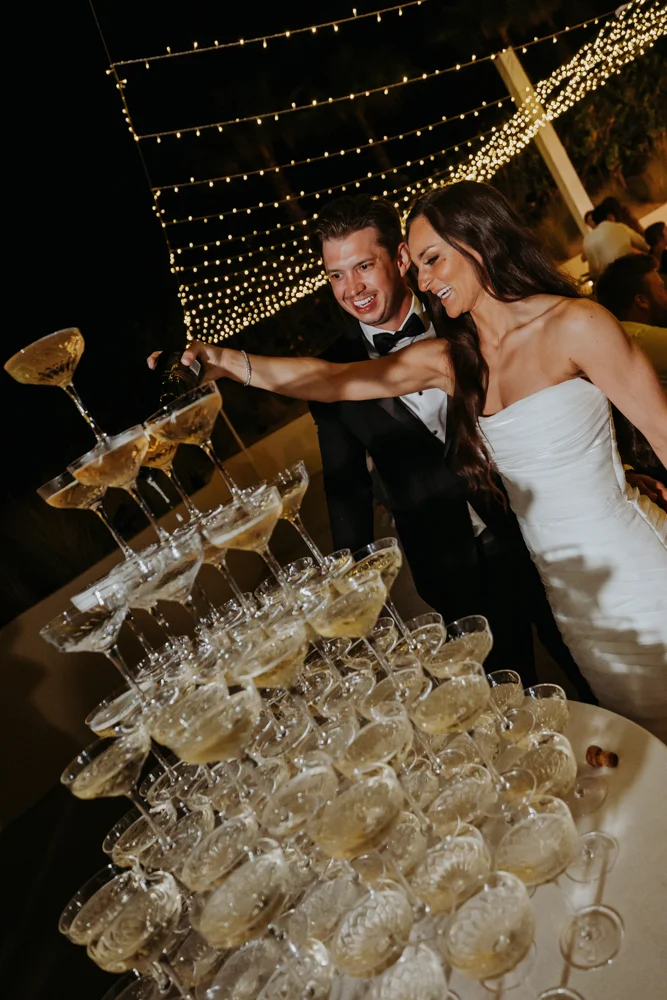 Bride and groom fill champagne glasses