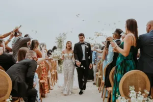 Newlyweds exit their ceremony as the guest throw flower petals