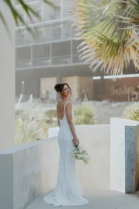 Bride looks back showing her gown and bouqtet