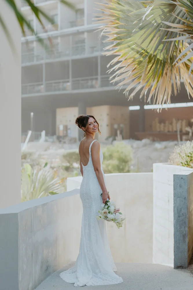 Bride looks back showing her gown and bouqtet