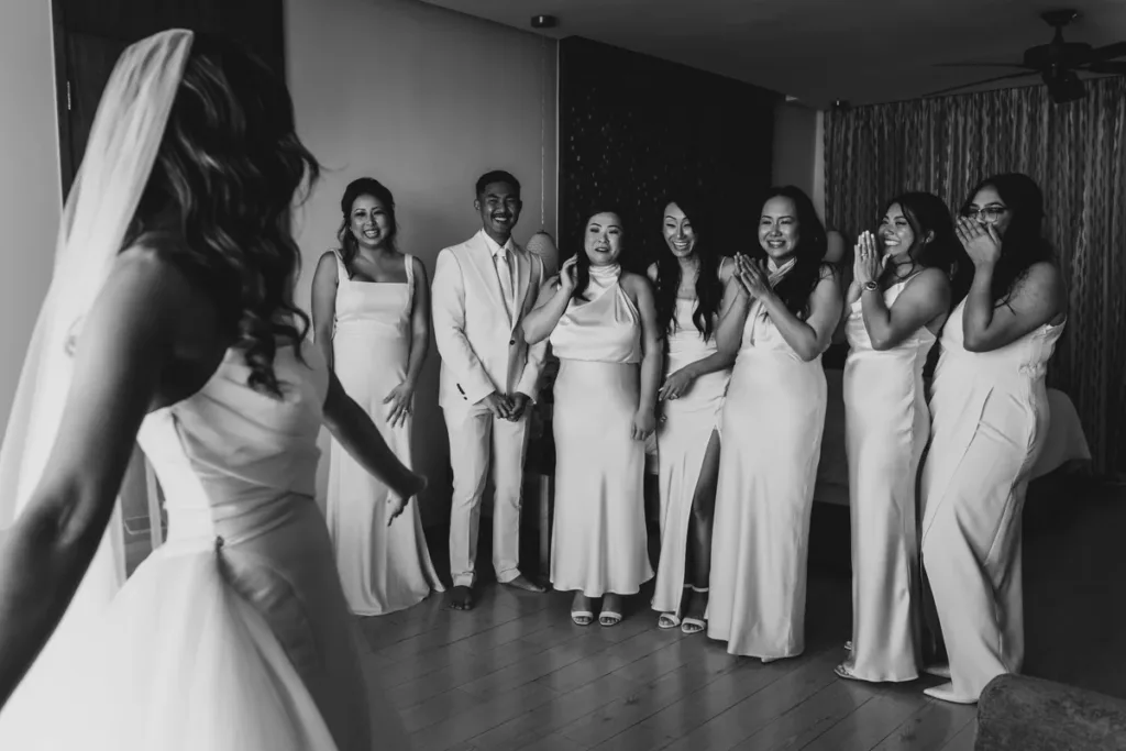 Bride shows her wedding gown to bridesmaids for the first time